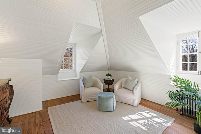 living area with wood-type flooring and lofted ceiling