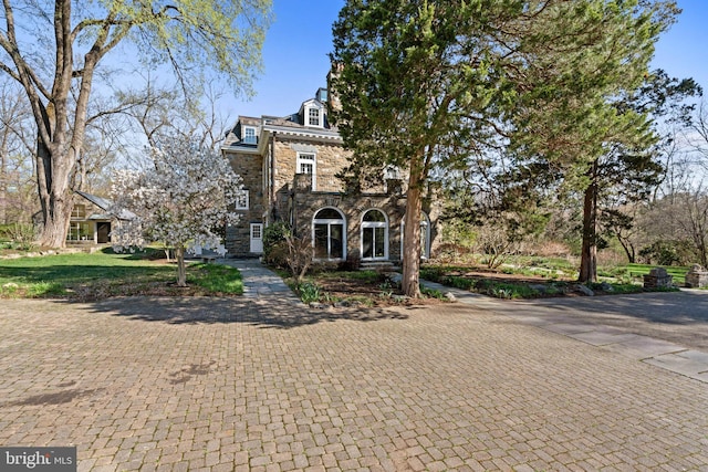shingle-style home featuring stone siding