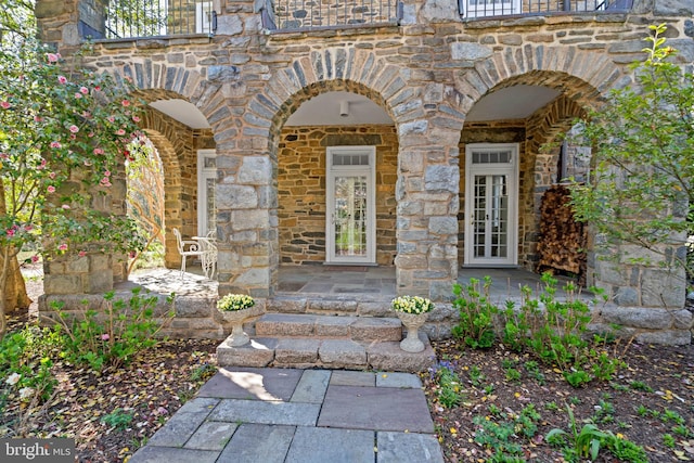property entrance featuring french doors and stone siding