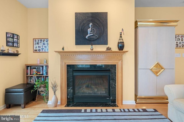 room details with a fireplace with flush hearth, baseboards, and wood finished floors