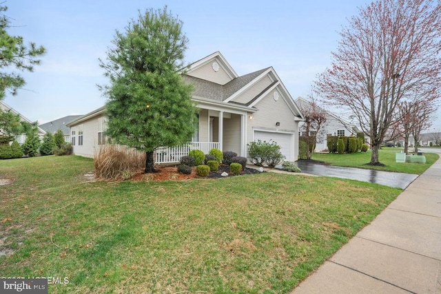 view of front facade with a garage, a front yard, a porch, and driveway