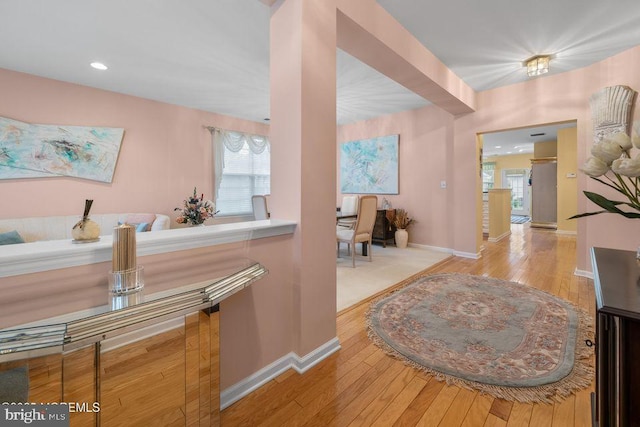 hallway with recessed lighting, light wood-style floors, and baseboards
