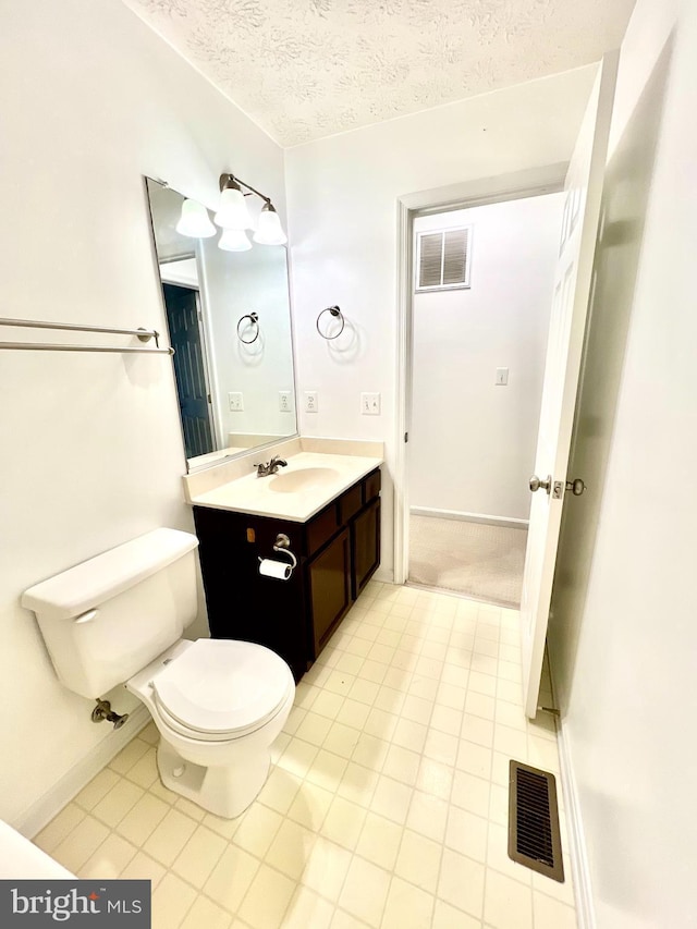 bathroom with visible vents, toilet, vanity, and a textured ceiling