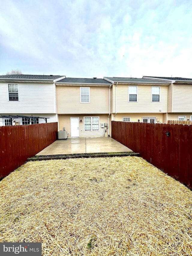 rear view of property with a patio, central air condition unit, and a fenced backyard