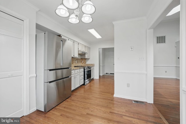 kitchen featuring light wood-style floors, backsplash, visible vents, and stainless steel appliances