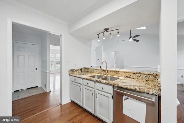 kitchen featuring crown molding, light stone countertops, stainless steel dishwasher, a sink, and wood finished floors