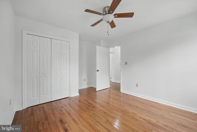 unfurnished bedroom featuring a closet, light wood finished floors, baseboards, and ceiling fan
