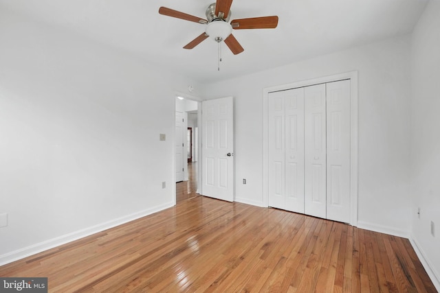 unfurnished bedroom featuring light wood-style flooring, a closet, and baseboards