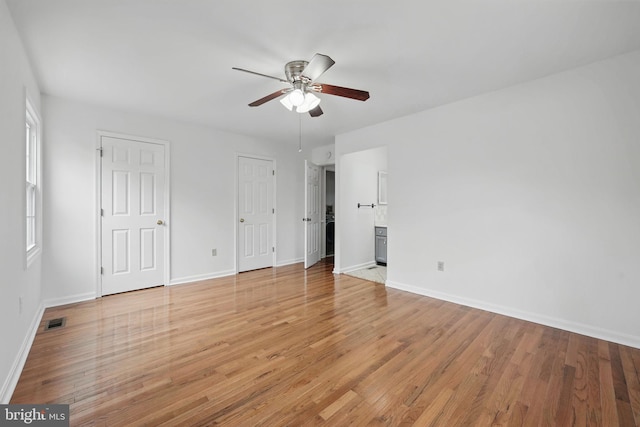 unfurnished bedroom with light wood-type flooring, visible vents, baseboards, and ceiling fan