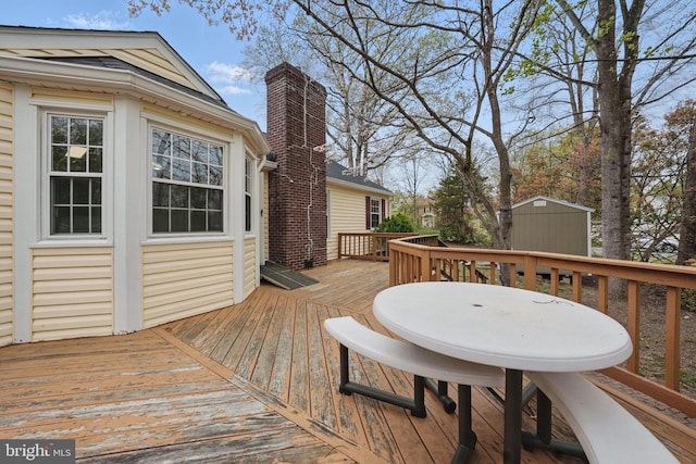 wooden deck with a storage shed and an outdoor structure