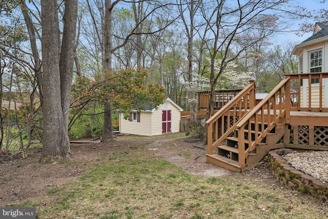 view of yard featuring a deck, an outdoor structure, stairs, and a storage unit