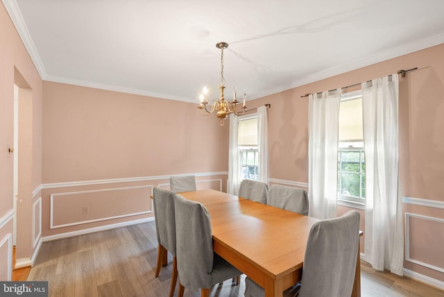 dining area with a chandelier, light wood-style floors, and crown molding