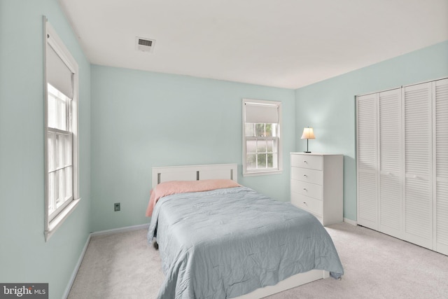 bedroom featuring light colored carpet, multiple windows, and baseboards