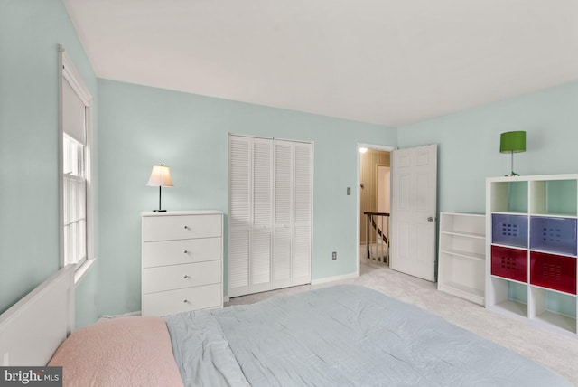 carpeted bedroom featuring a closet and baseboards