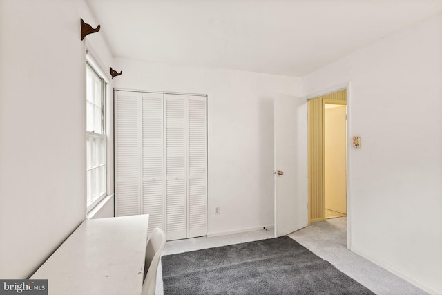unfurnished bedroom with carpet floors, a closet, and baseboards