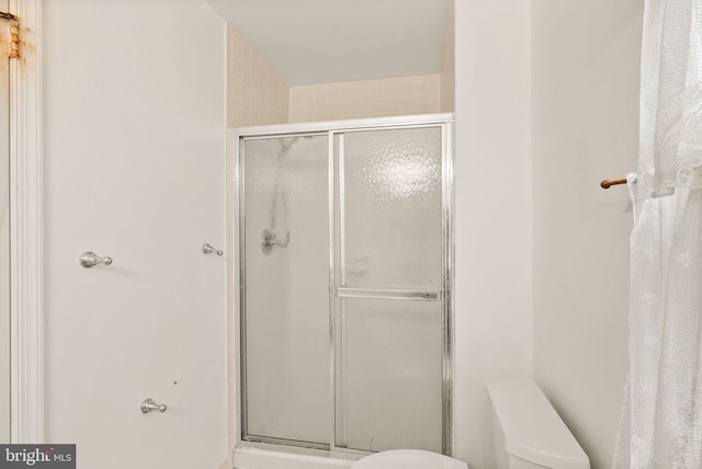 full bath with toilet and a stall shower
