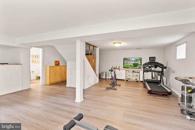 exercise room with light wood-style floors and baseboards