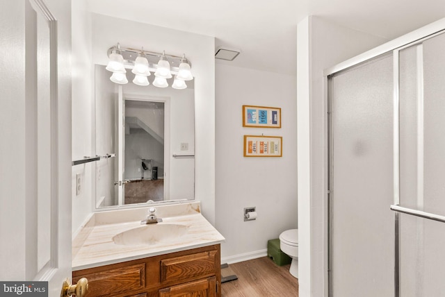 full bath with toilet, wood finished floors, vanity, a shower stall, and baseboards