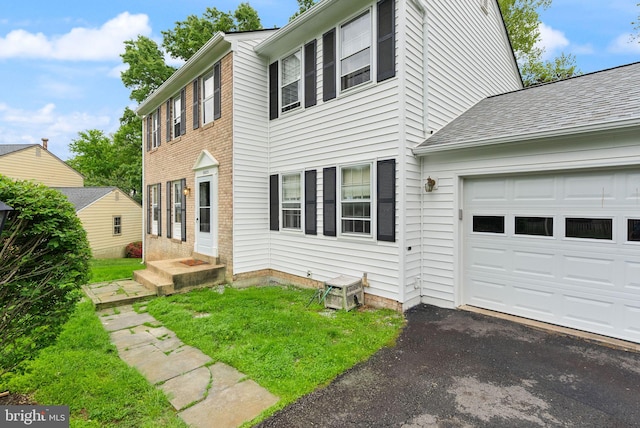 view of property exterior with an attached garage and asphalt driveway