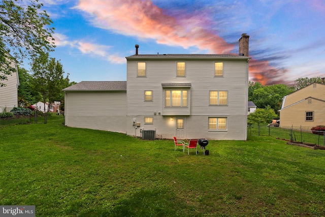 rear view of property with central AC unit and a chimney