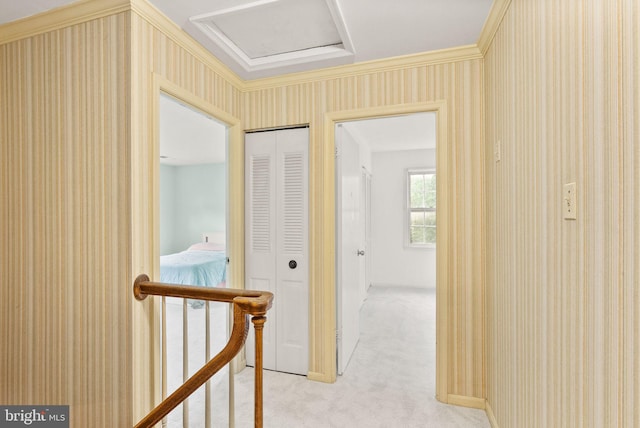 corridor featuring light colored carpet, attic access, wallpapered walls, and an upstairs landing