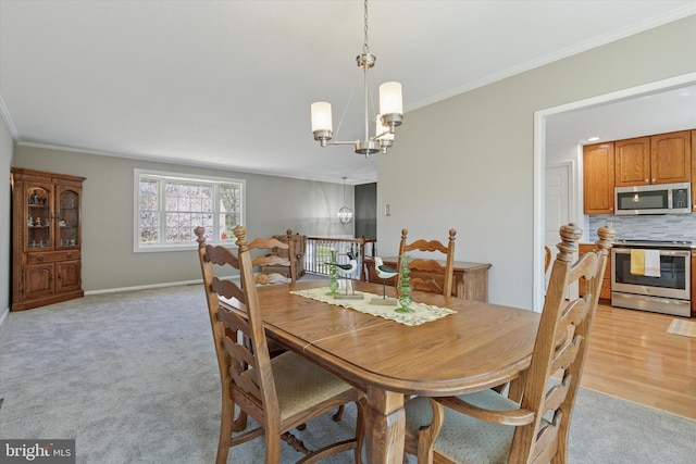dining space with crown molding, light colored carpet, and a notable chandelier