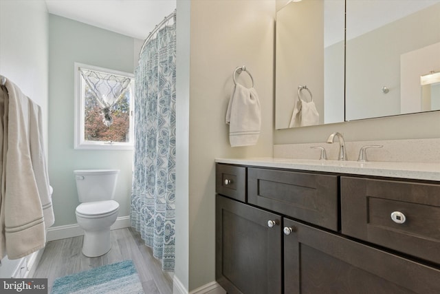 full bath with vanity, baseboards, toilet, and wood finished floors