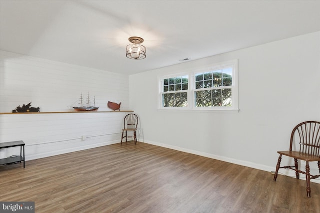 interior space with wood finished floors, baseboards, and visible vents