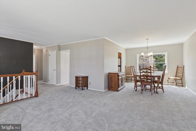 carpeted dining room with an inviting chandelier, baseboards, and ornamental molding