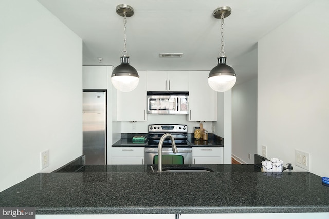 kitchen featuring visible vents, white cabinetry, decorative light fixtures, and stainless steel appliances