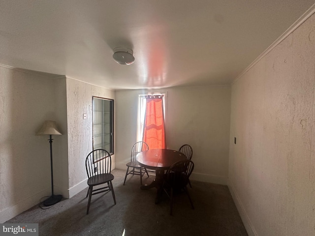 carpeted dining area with crown molding, a textured wall, and baseboards