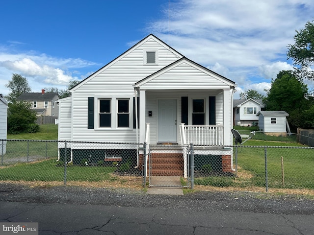 view of front of property featuring covered porch, a fenced front yard, and a gate