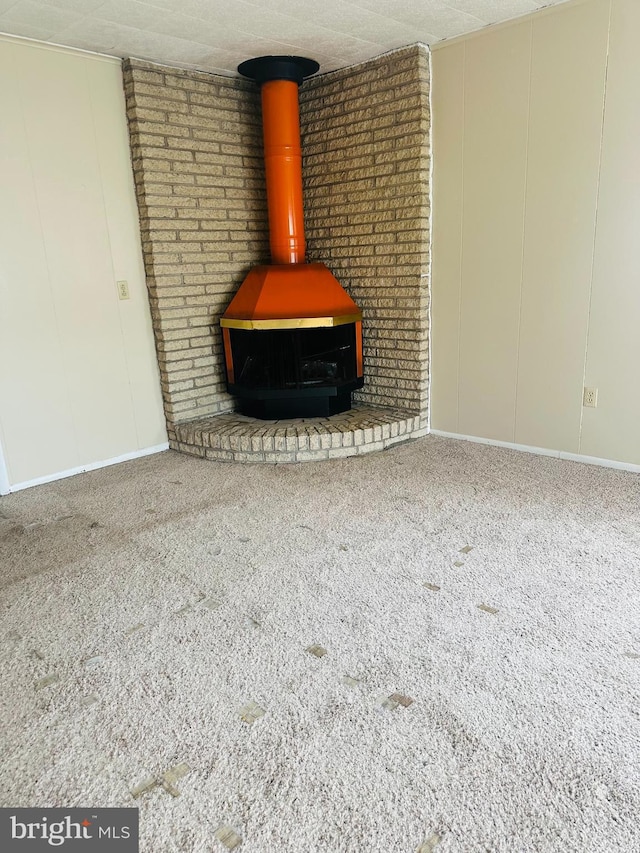 5001 Franklin St, Harrisburg, PA 17111 - interior details featuring a decorative wall, a wood stove, carpet, and baseboards