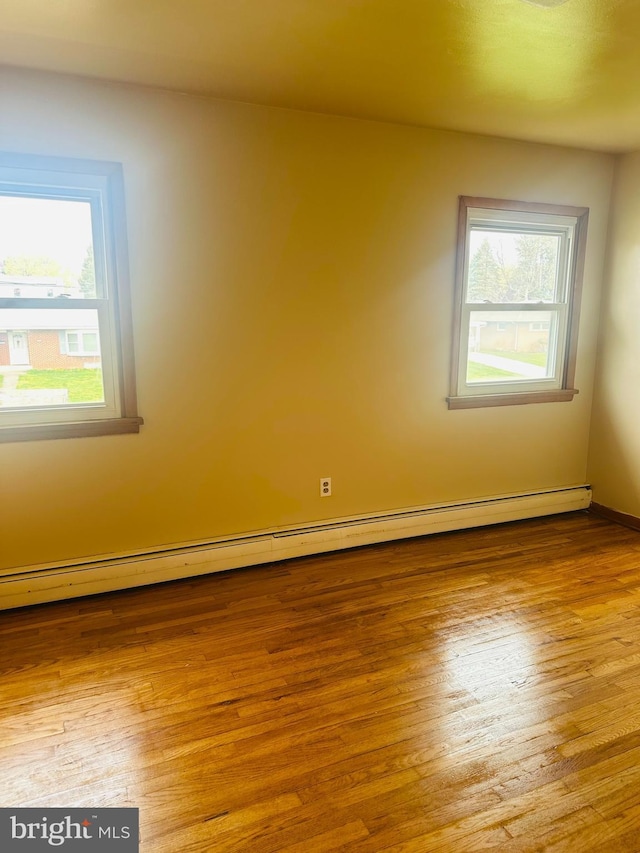 5001 Franklin St, Harrisburg, PA 17111 - unfurnished room with a baseboard radiator, a healthy amount of sunlight, and wood finished floors