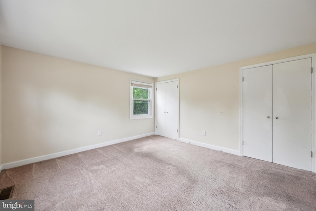 12430 Shadow Ln, Bowie, MD 20715 - unfurnished bedroom featuring two closets, baseboards, and carpet