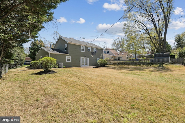 view of yard with a fenced backyard and french doors