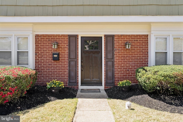 entrance to property featuring brick siding