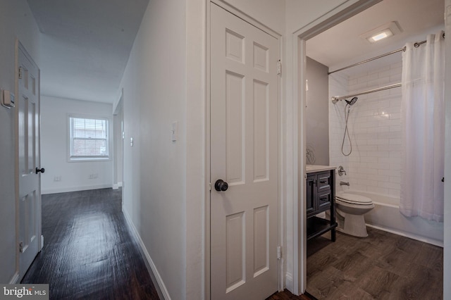 hall featuring baseboards and dark wood-style floors