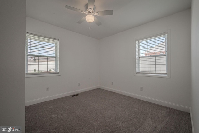 carpeted empty room with visible vents, baseboards, and ceiling fan