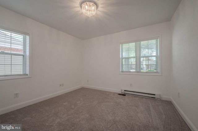 carpeted empty room featuring a baseboard heating unit, baseboards, and an inviting chandelier