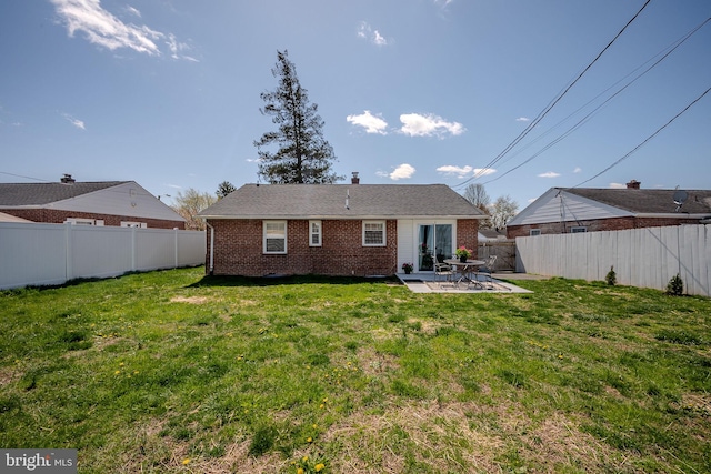 rear view of house featuring a patio, a yard, a fenced backyard, and brick siding