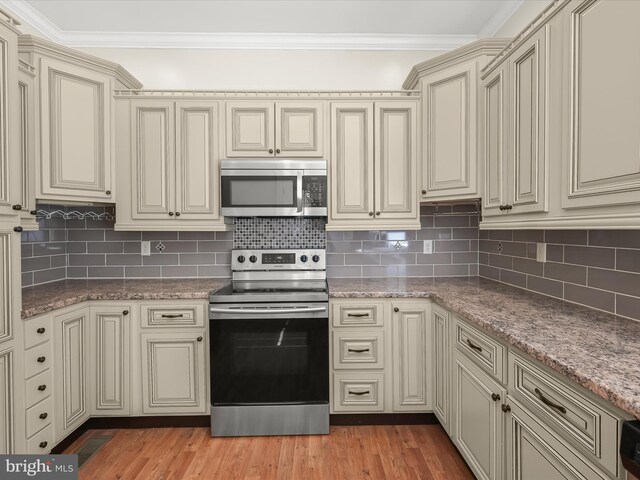 13 N Allegany St, Cumberland, MD 21502 - kitchen featuring stainless steel appliances, cream cabinets, crown molding, and tasteful backsplash