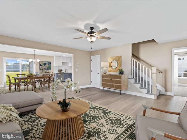 200 School Rd, Bethel, DE 19931 - living room featuring stairway, light wood-type flooring, ceiling fan with notable chandelier, and baseboards