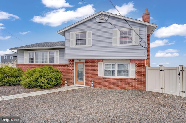 33 W Delaware Dr, Little Egg Harbor Twp, NJ 08087 - split level home with brick siding, fence, and a gate