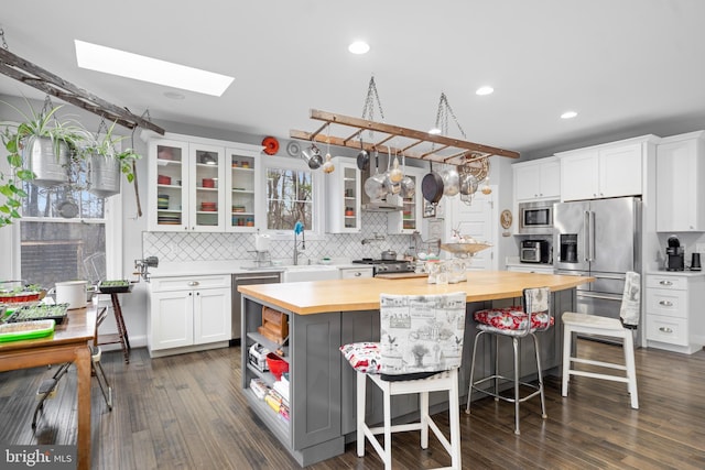 173 Puffball Rd, Hedgesville, WV 25427 - kitchen featuring backsplash, wooden counters, white cabinets, a skylight, and stainless steel appliances