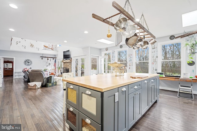 173 Puffball Rd, Hedgesville, WV 25427 - kitchen with a stone fireplace, a skylight, gray cabinetry, and dark wood-style flooring