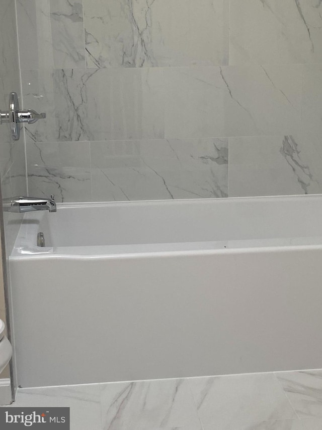 bathroom featuring a tub and toilet