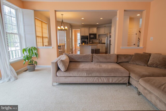 12253 Tulane Falls Dr, Bristow, VA 20136 - carpeted living room with baseboards, an inviting chandelier, and recessed lighting