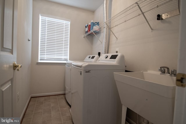 12253 Tulane Falls Dr, Bristow, VA 20136 - clothes washing area with baseboards, washer and dryer, laundry area, and a sink