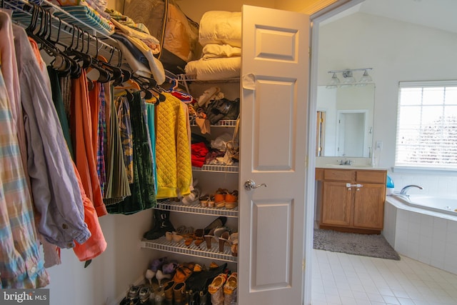 12253 Tulane Falls Dr, Bristow, VA 20136 - walk in closet with vaulted ceiling, a sink, and light tile patterned floors